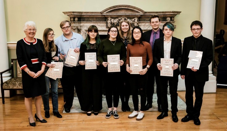 Young musicians holding award certificates